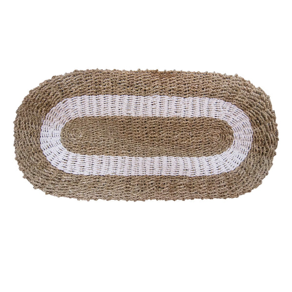 Oval-shaped woven seagrass mat with a white center on a white background